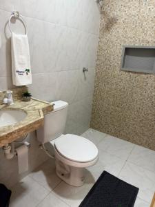 a bathroom with a toilet and a sink and a shower at Pousada VillageMar in Cascavel +27 photos