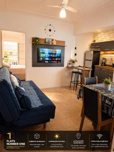 a living room with a couch and a kitchen at Flats Number One in Ribeirão Preto