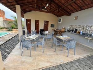 a patio with tables and chairs next to a pool at Pousada VillageMar in Cascavel