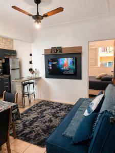 a living room with a couch and a tv on the wall at Flats Number One in Ribeirão Preto