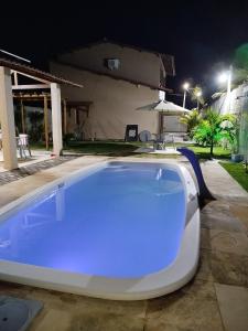 a swimming pool at night with a blue light at Pousada VillageMar in Cascavel