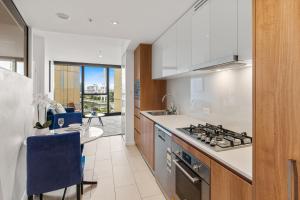 a kitchen with a sink and a stove top oven at CBD RiverView 2Bed Apt Kingbed at Tallest building in Brisbane