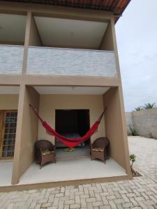 a hammock on the porch of a house at Pousada VillageMar in Cascavel