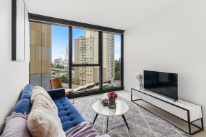 a living room with a blue couch and a large window at CBD RiverView 2Bed Apt Kingbed at Tallest building in Brisbane