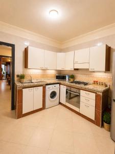 a kitchen with white cabinets and a dishwasher at Résidence El Harti in Marrakesh