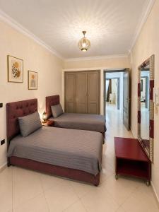 a bedroom with two beds and a mirror at Résidence El Harti in Marrakesh