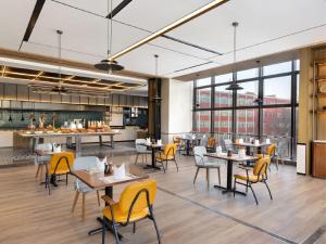 a dining room with tables and yellow chairs at Four Points by Sheraton Jinan, High-Tech Zone in Jinan