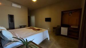 a bedroom with a bed and a potted plant at Alfa Beach in Cacha Pregos