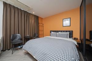 a bedroom with a large bed and two chairs at 동대문 벨루스 호텔 in Seoul +10 photos