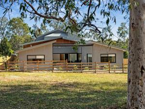 a house with a fence in front of it at Sereno in Pokolbin