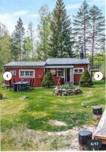 a red barn with a picnic table in the yard at Nature & Tranquility in Örebro