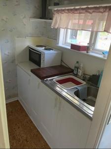 a small kitchen with a sink and a microwave at Nature & Tranquility in Örebro