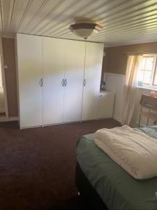 a bedroom with white cabinets and a bed at Nature & Tranquility in Örebro