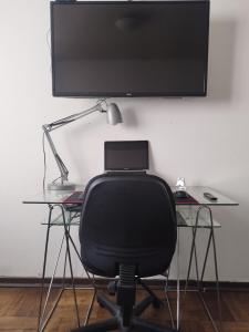 a desk with a chair and a monitor on a wall at Habitación Doble en Dpto compartido in Santiago