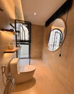 a bathroom with a toilet and a round mirror at The Sol Hotel in Phú Quốc +24 photos