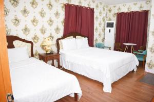 two beds in a room with red curtains at Koa Guest House in Angeles