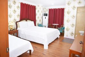 a hotel room with two beds and red curtains at Koa Guest House in Angeles