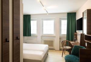 a room with a bed and a desk and a chair at Arthotel ANA Liberty, Trademark Collection by Wyndham in Bremen +72 photos
