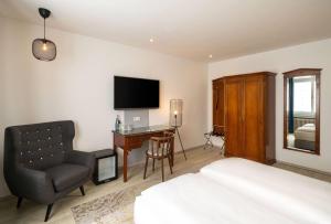 a bedroom with a bed and a desk and a chair at Arthotel ANA Liberty, Trademark Collection by Wyndham in Bremen