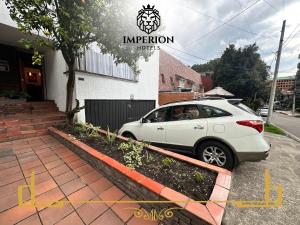 a white car parked in front of a building at Casa Hotel Imperion in Bogotá