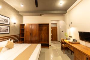 a bedroom with a bed and a desk and a television at Aqualuna Weligama in Weligama +41 photos