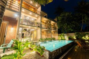 a house with a swimming pool in front of it at Aqualuna Weligama in Weligama