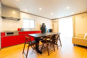 a kitchen with a table and chairs in a room at アドベンまで5分で4連棟の最大30名のゲストハウス in Shirahama