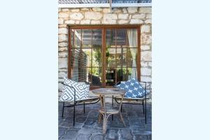 a patio with chairs and a table and a window at Duilius in Robe