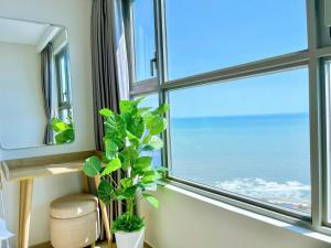 a window with a view of the ocean at The Sóng Vũng Tàu - Căn Hộ Nghỉ Dưỡng, Hồ Bơi Vô Cực & Gần Biển - Mr T in Vung Tau