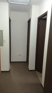 an empty hallway with three doors in a building at Casa Linares in Linares