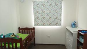 a room with two cribs and a window with a curtain at Casa Linares in Linares
