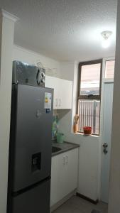 a kitchen with a stainless steel refrigerator and a window at Casa Linares in Linares