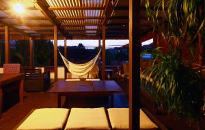 a porch with a hammock and a table and a hammock at ゲストハウス303 in Zamami