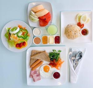 drei weiße Teller mit Essen auf einem Tisch in der Unterkunft I Residence Hotel Sathorn in Bangkok