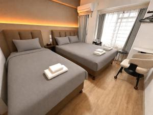 a hotel room with two beds and a chair at Lucky NAMBA 大阪難波 なんば in Osaka