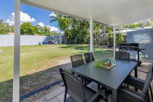 a table and chairs on a patio with a grill at Anchor and Palms in Agnes Water