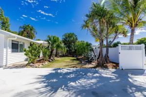 a house with palm trees and a white fence at Anchor and Palms in Agnes Water