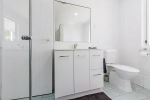 a white bathroom with a sink and a toilet at Anchor and Palms in Agnes Water +28 photos