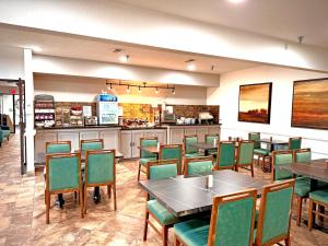 a restaurant with tables and chairs and a counter at SureStay Plus by Best Western Cannon A.F.B. in Clovis