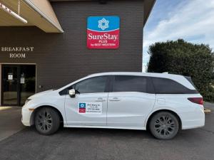 a white car parked in front of a building at SureStay Plus by Best Western Cannon A.F.B. in Clovis