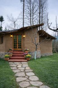 a small house with a pathway leading to it at Sarayu Farmstays in Manāli
