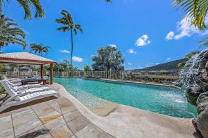 a swimming pool with a gazebo and palm trees at Spa Haven 17B Ocean View in Airlie Beach