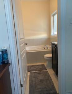 a bathroom with a bath tub and a toilet at Divinity Hut in Brampton