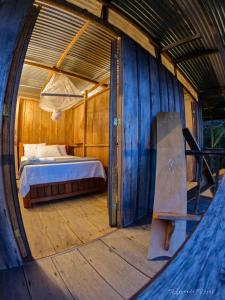 a bedroom with a bed in a wooden house at El Nido in La Macarena +32 photos