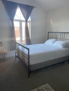 a bed in a bedroom with a large window at Divinity Hut in Brampton