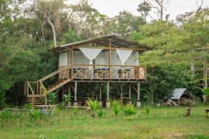 a tree house with two chairs and a porch at El Nido in La Macarena