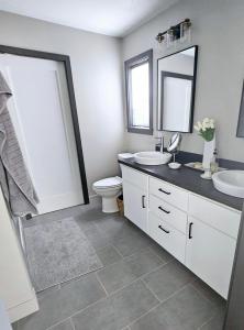 a bathroom with a sink and a toilet and a mirror at Charming New Lake House in Pierre +12 photos