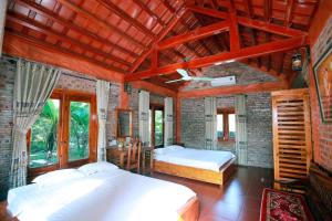 a bedroom with two beds and a brick wall at Ninh Binh Mountain View Homestay & Restaurant in Ninh Binh +75 photos
