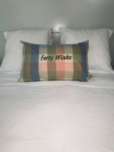 a pillow sitting on top of a white bed at 40 Winks in Otorohanga