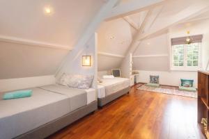 a bedroom with two beds and a wooden floor at Luxurious 4BR Villa in Vairoa